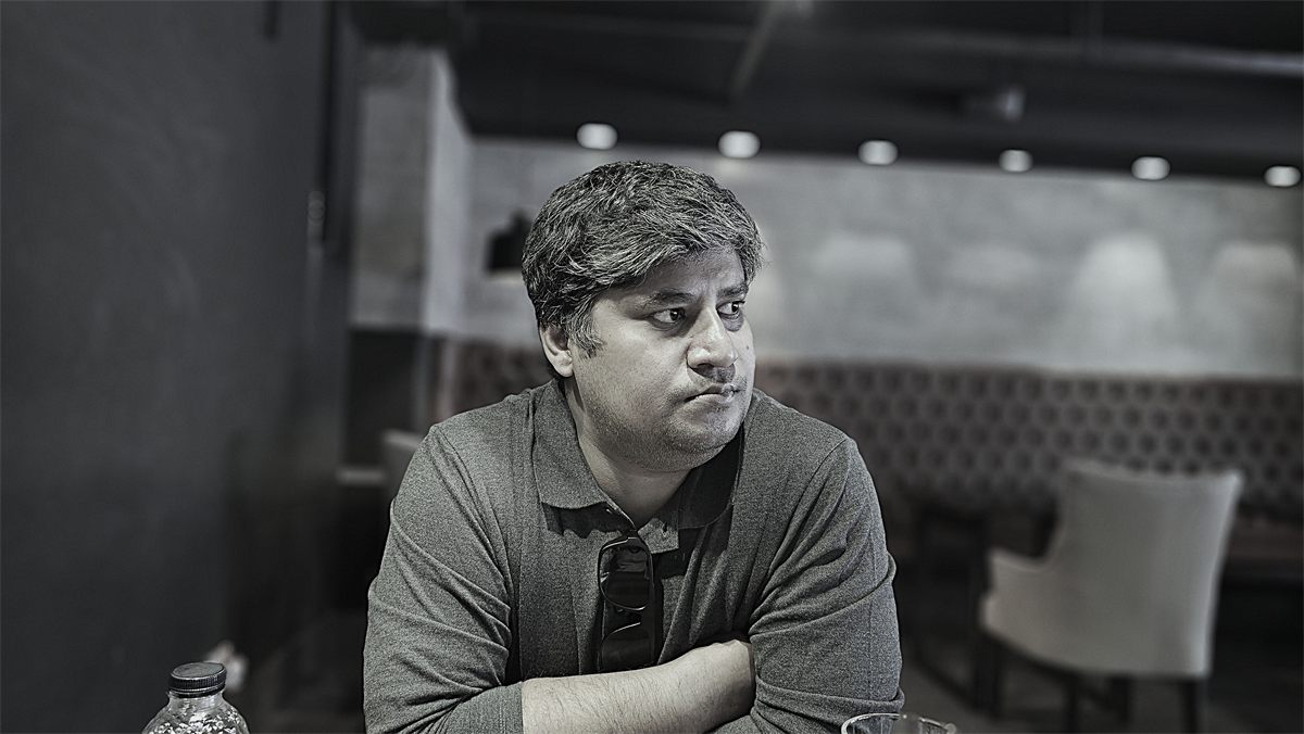 Black-and-white portrait of a man seated at a restaurant