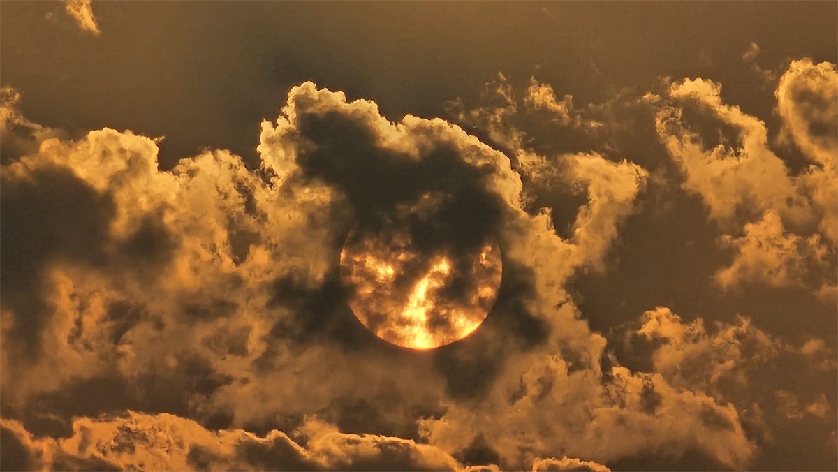 The setting sun glowing through dramatic clouds at Cox's Bazar